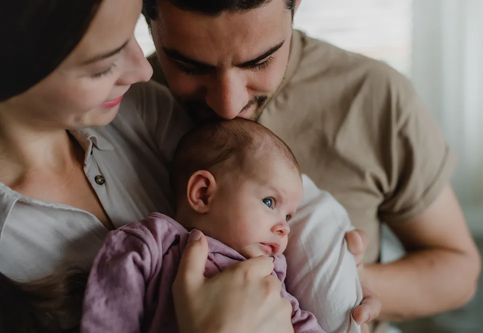 Mother and father trying to keep baby up during naptime.