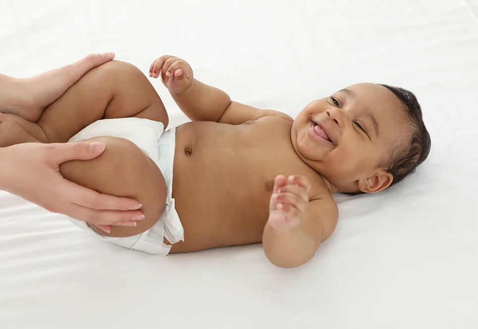 Happy mixed race baby getting a baby massage from mom.