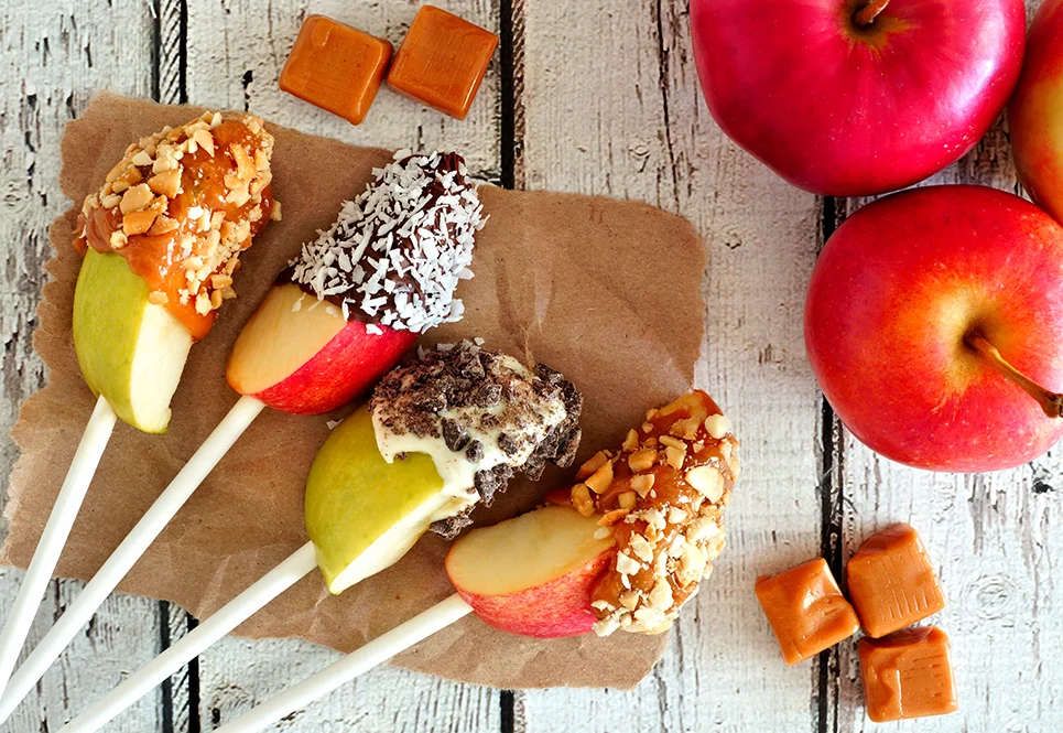 Apple slices on sticks covered in sweet toppings