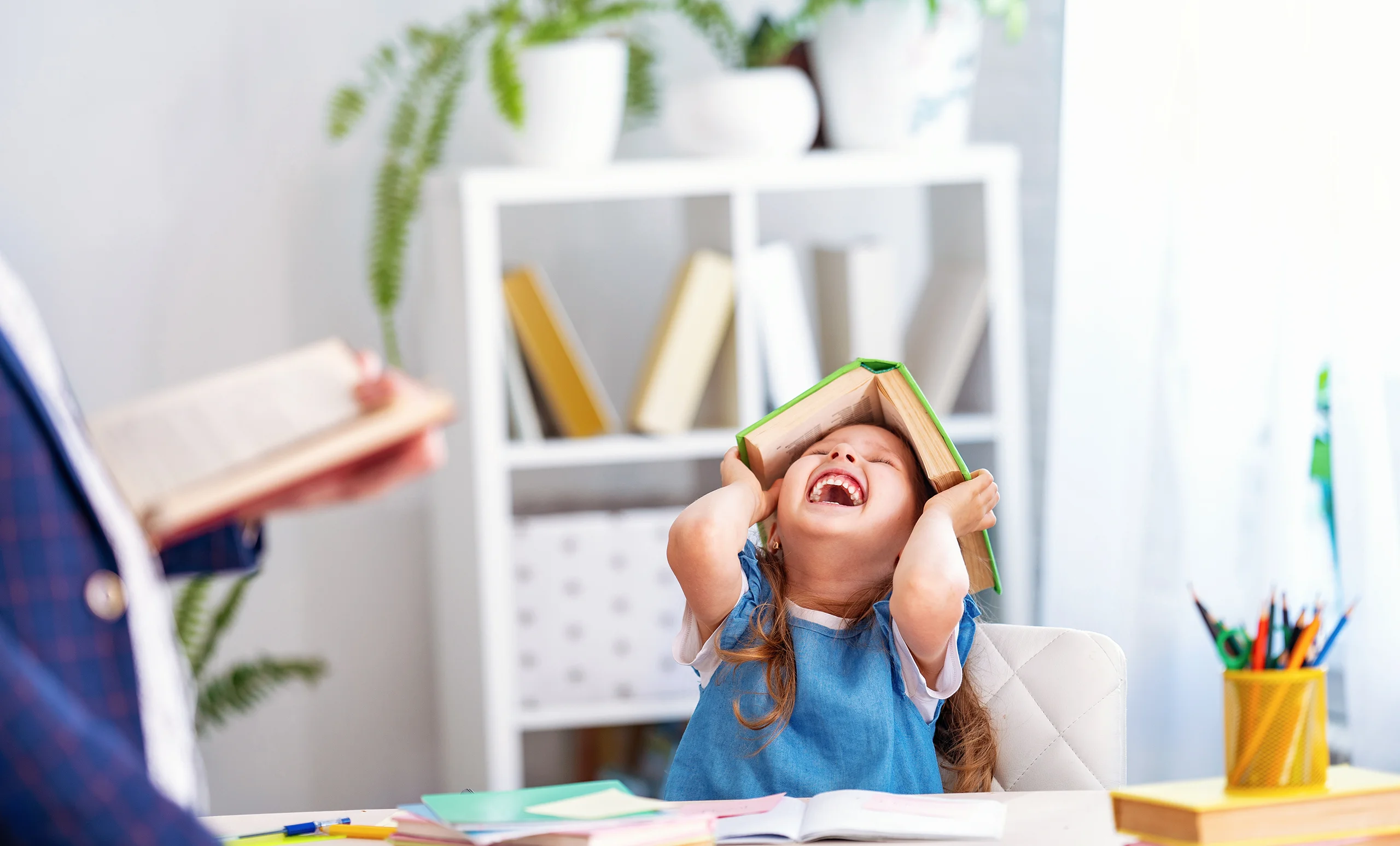 Little caucasian girl playing with a book instead of reading it