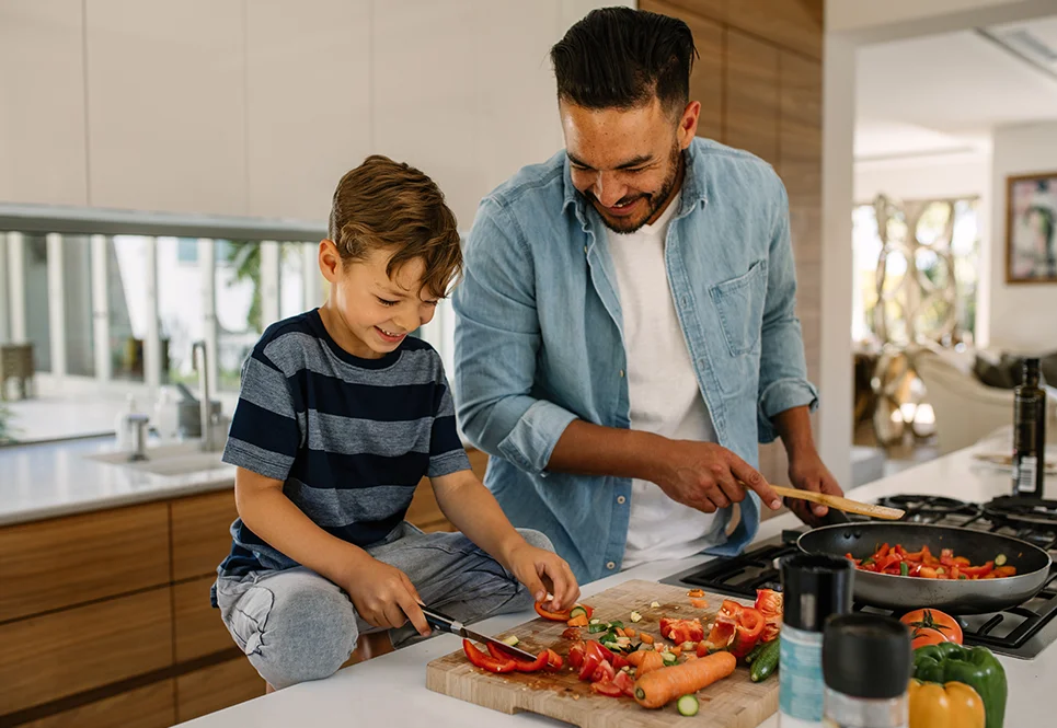 Caucasian father cooking healthy food with his son. 