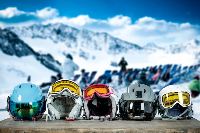 Five children’s skiing helmets lined up outside. 