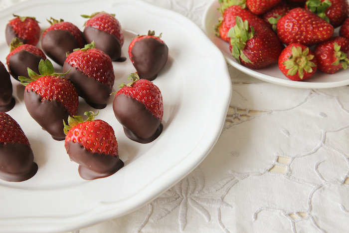 Closeup shot of dark chocolate-dipped strawberries on a plate. 