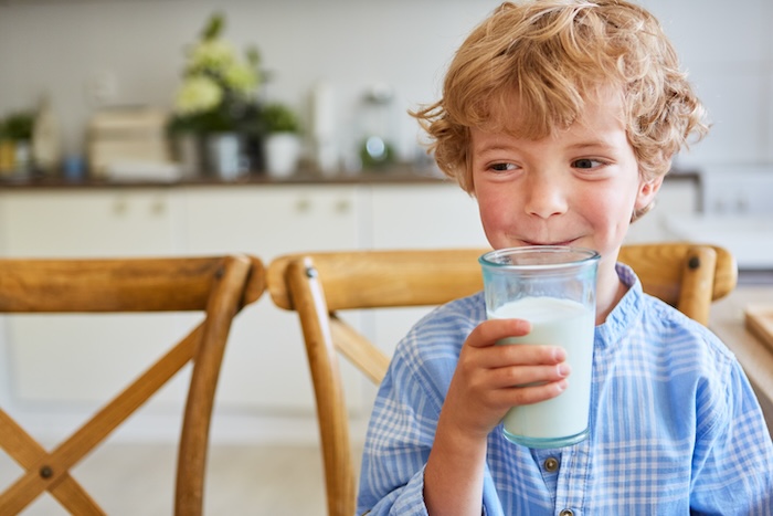 Young caucasian boy drinking a glass of milk