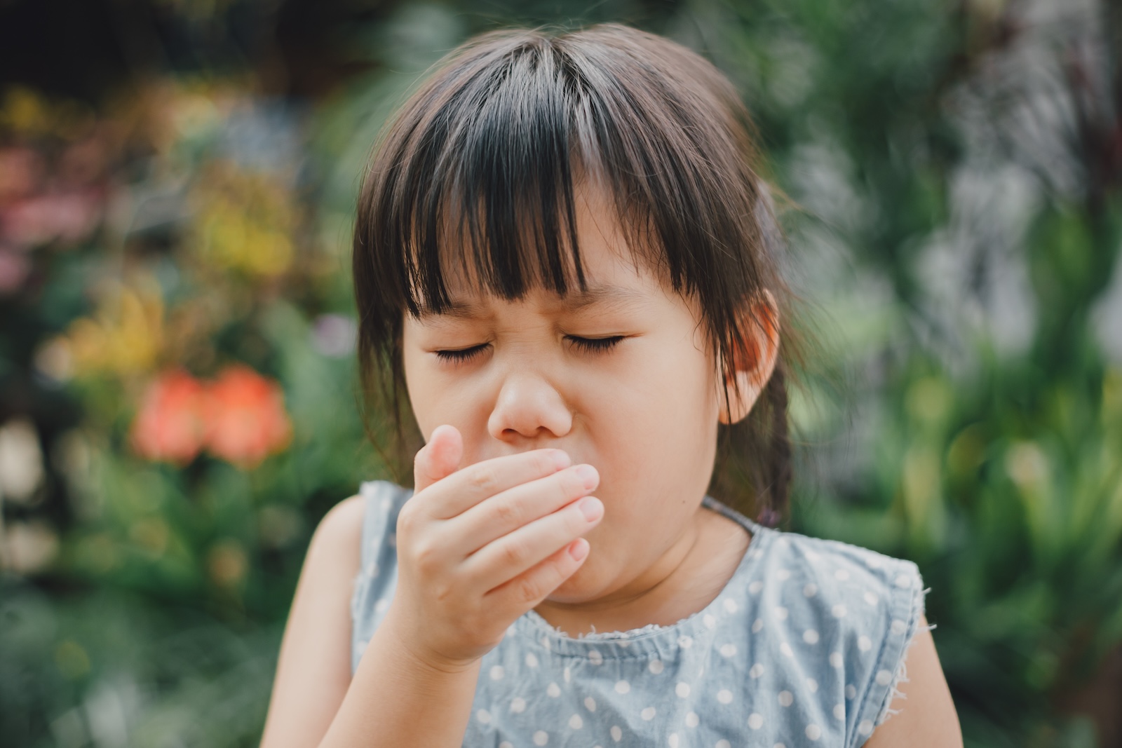 Young asian girl coughing