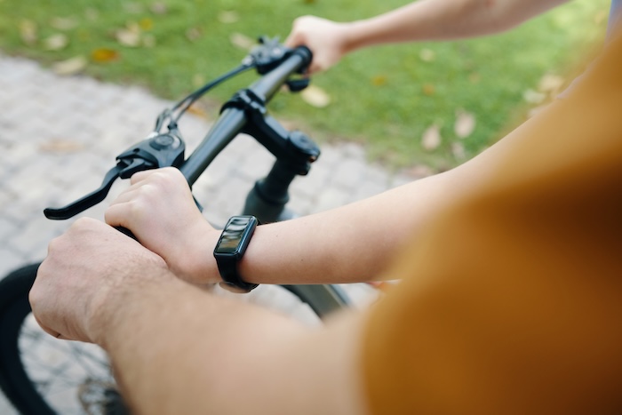 Shot of child riding a bike with their father.