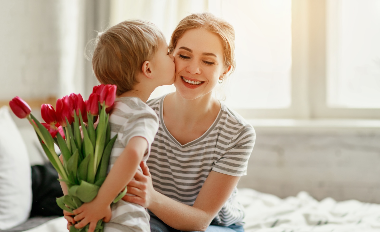 Young boy giving his mom roses on Mother’s Day.