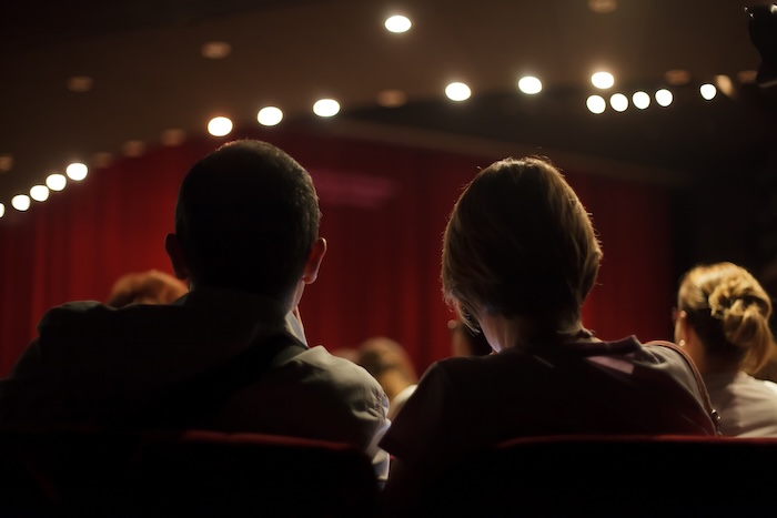 Mother watching a play at a local playhouse. 