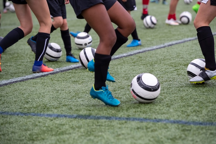 closeup of child's legs in a soccer summer camp