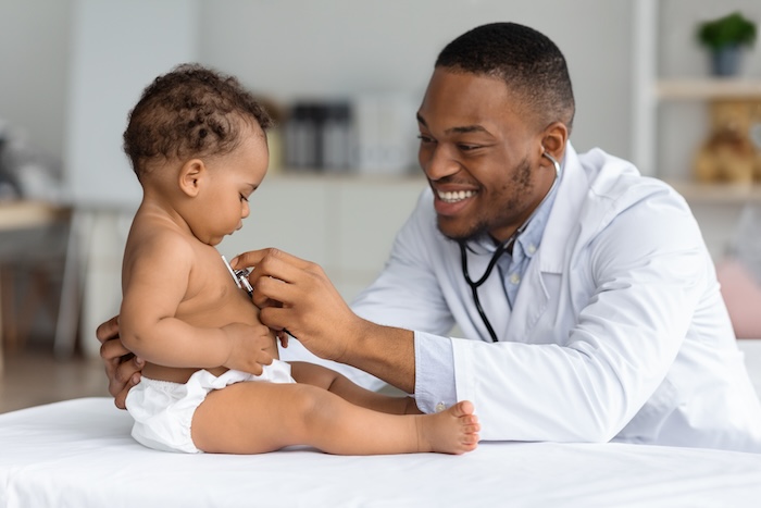Young Black pediatrician using a stethoscope to check a baby patient