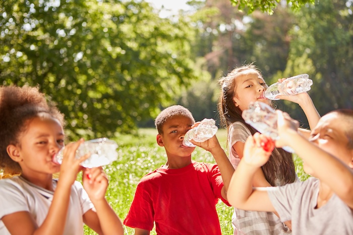 Group of young children drinking water. 