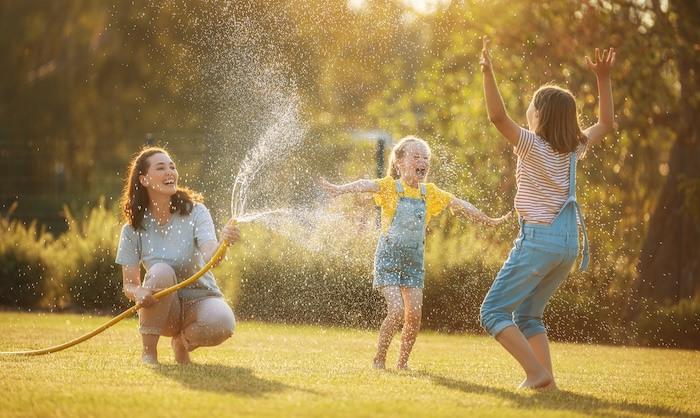 Kids playing in the sprinklers during late afternoon. 