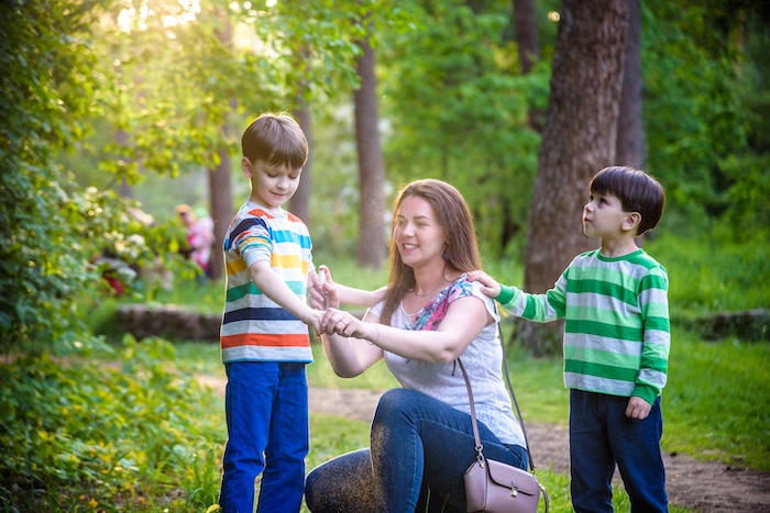 Young family outside walking in a forest. 