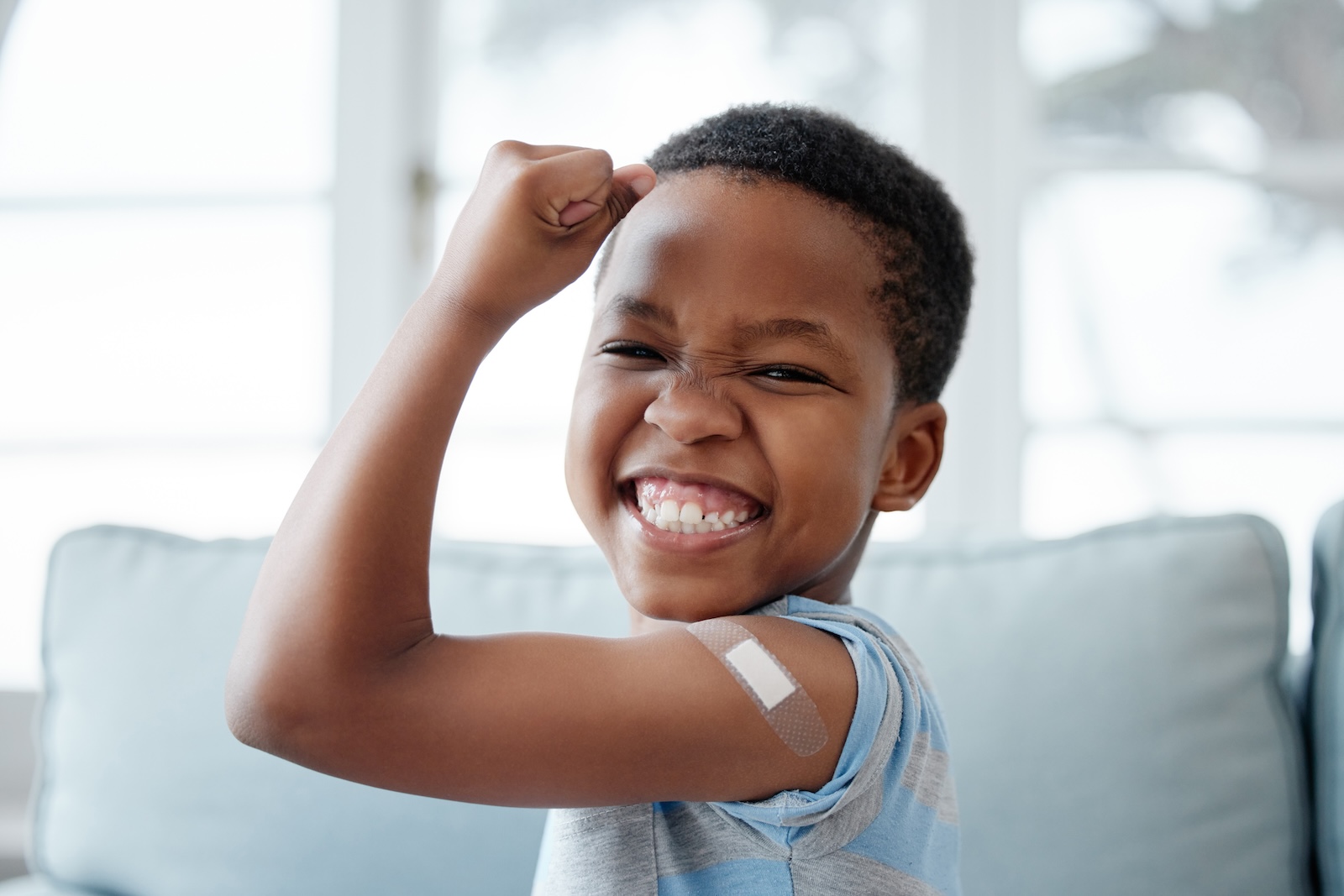 African American child smiling with a bandaid on his arm.