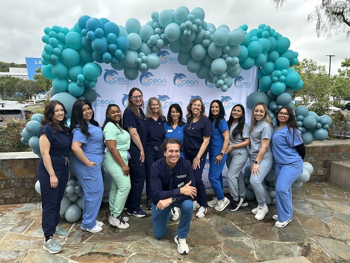 Ocean Pediatrics team smiling in front of their Orange County pediatric office.