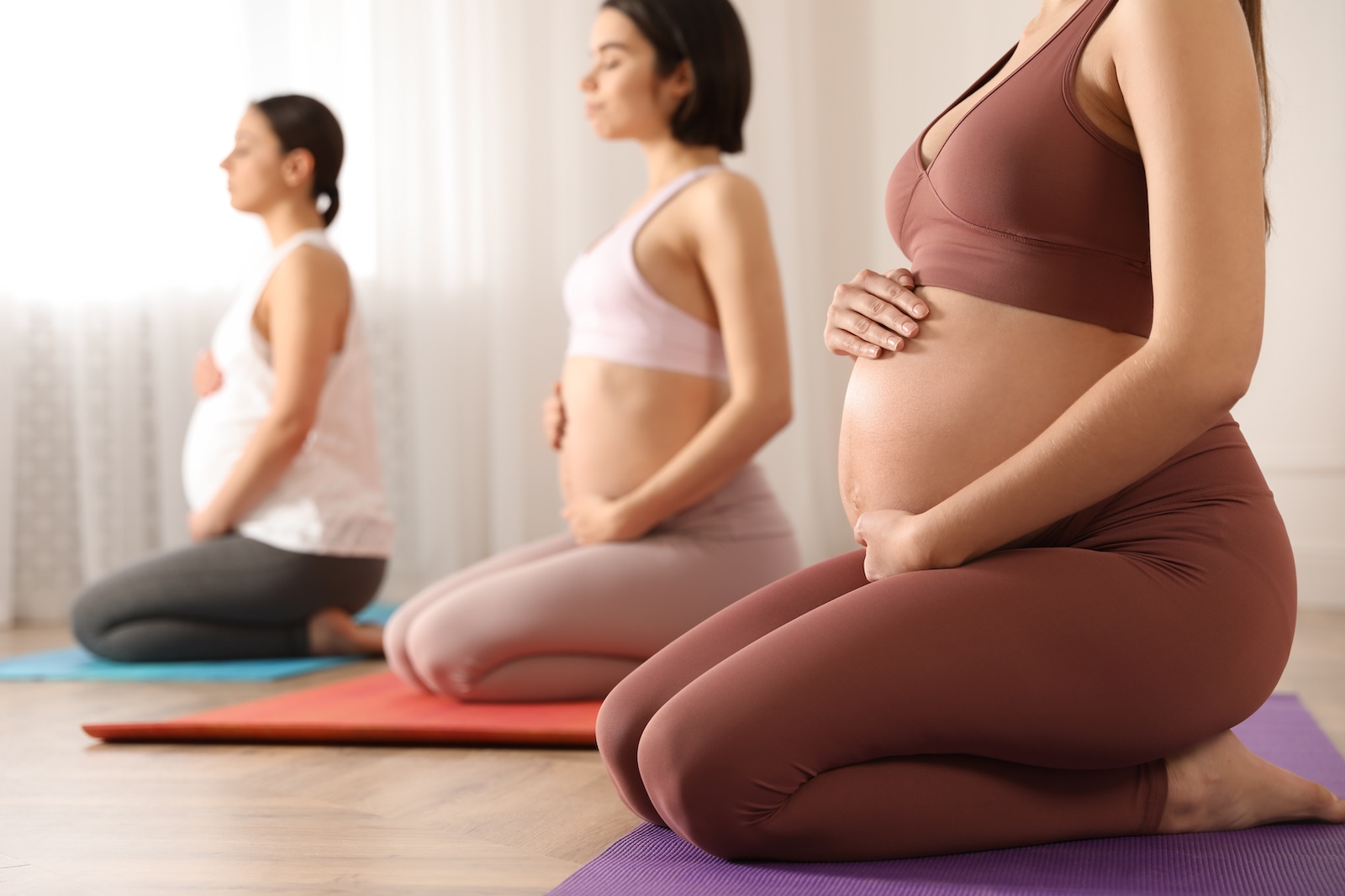 Closeup of pregnant women in a yoga class.