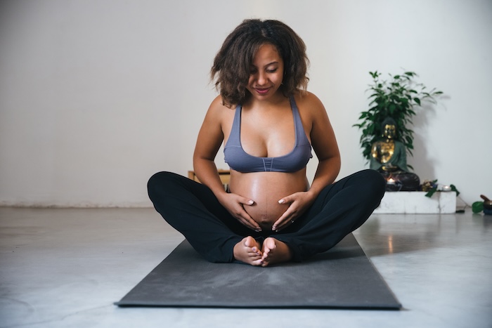 East Asian pregnant woman doing yoga at home. 