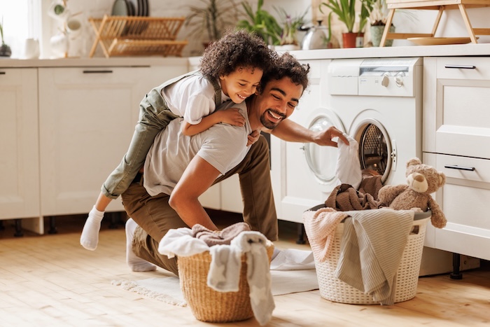 Dad doing laundry with children. 