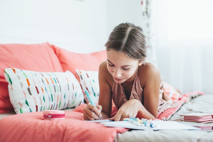 Young teenage girl writing her feelings in her journal. 