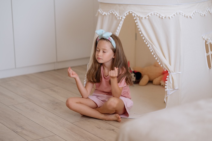 Young caucasian girl meditating at home