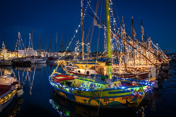  Lit up boats in a harbor during the holiday season.
