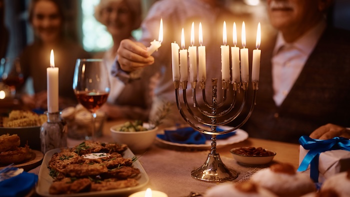 Family lighting a Hanukkah Menorah. 