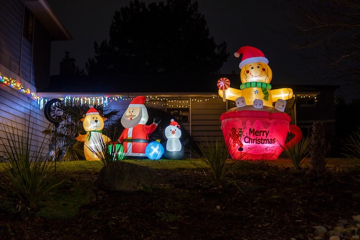 Outside of a home with inflatable Christmas decorations. 