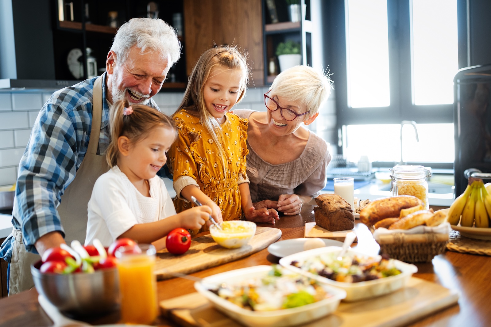 Grandparents smiling in the kitchen with grandchildren