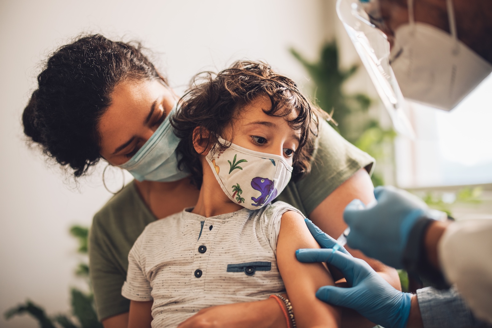 Ethnically ambiguous mother with her child getting a vaccine.