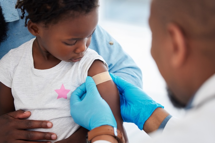 Closeup of a young black toddler getting a vaccine.