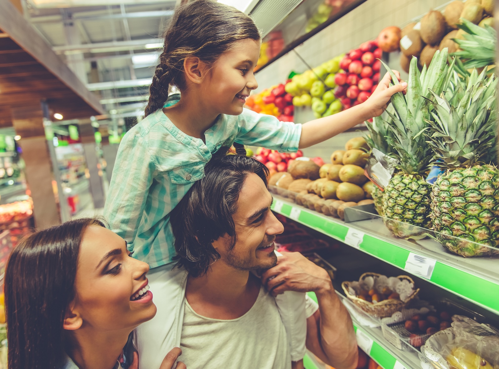 Young family shopping for fruit at a grocery store.