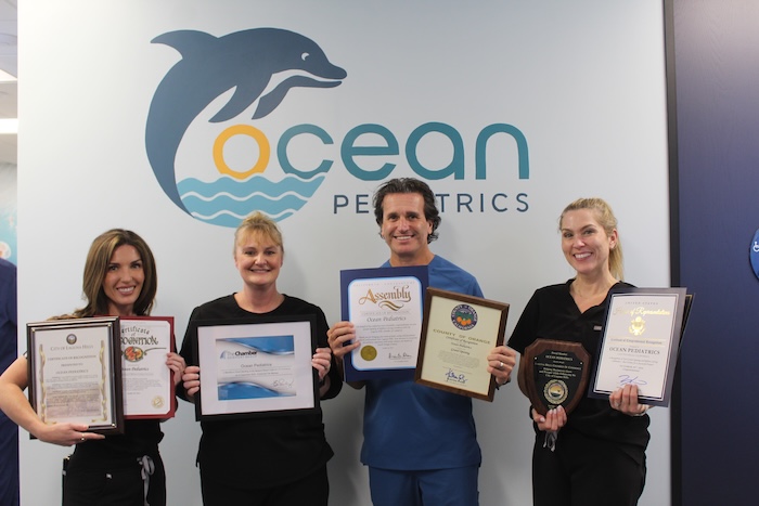 Ocean Pediatrics staff holding up certificates and awards.