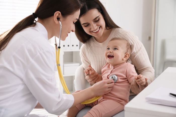 Infant smiling and laughing at her first pediatric office appointment. 