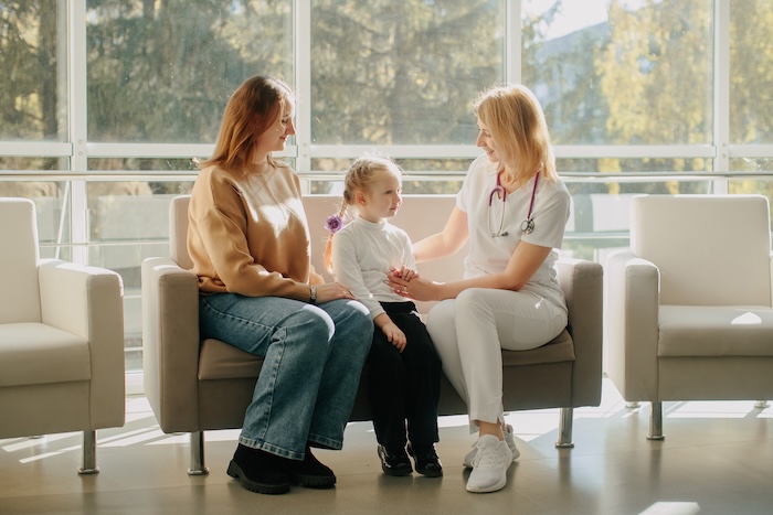 Young mom speaking with a female pediatrician in a hospital.