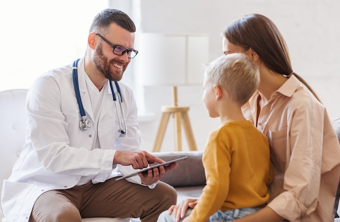 Caucasian mother and young son at a pre-travel visit to their pediatrician’s office.