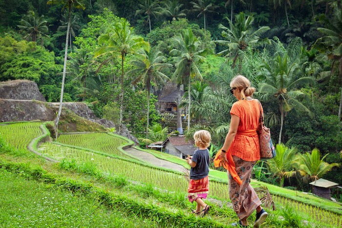 Caucasian mom and young son walking through a farm in a village on vacation.