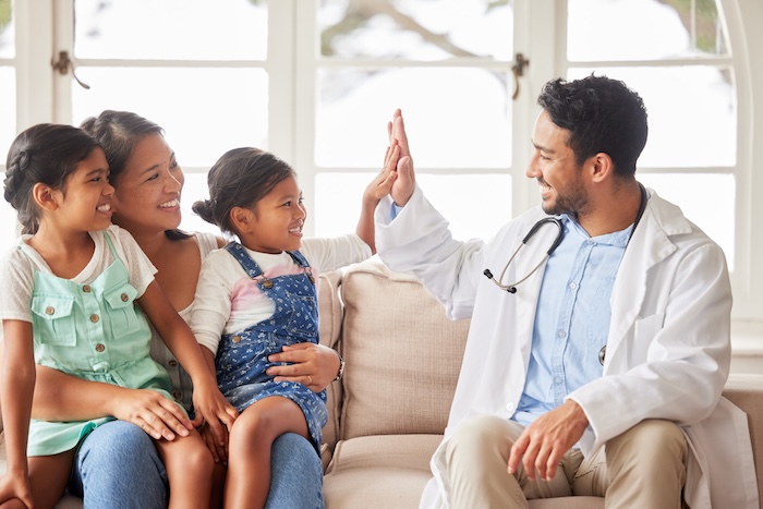 Happy Asian family smiling with their new pediatrician.