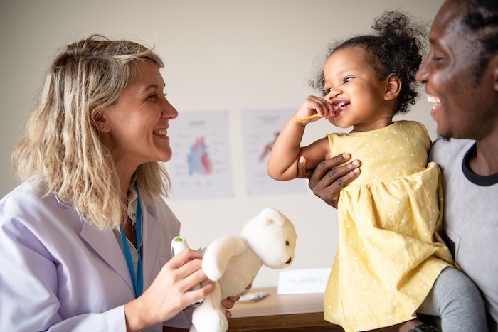 Black father and daughter at the child’s pediatric office.