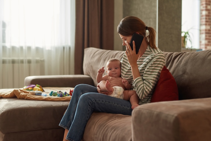 Mother on the phone, booking a same-day sick visit at Ocean Pediatrics.