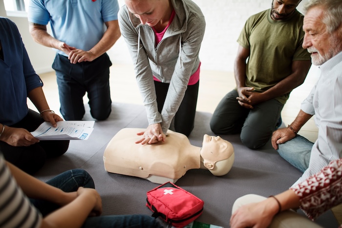 Young woman learning CPR in a class.