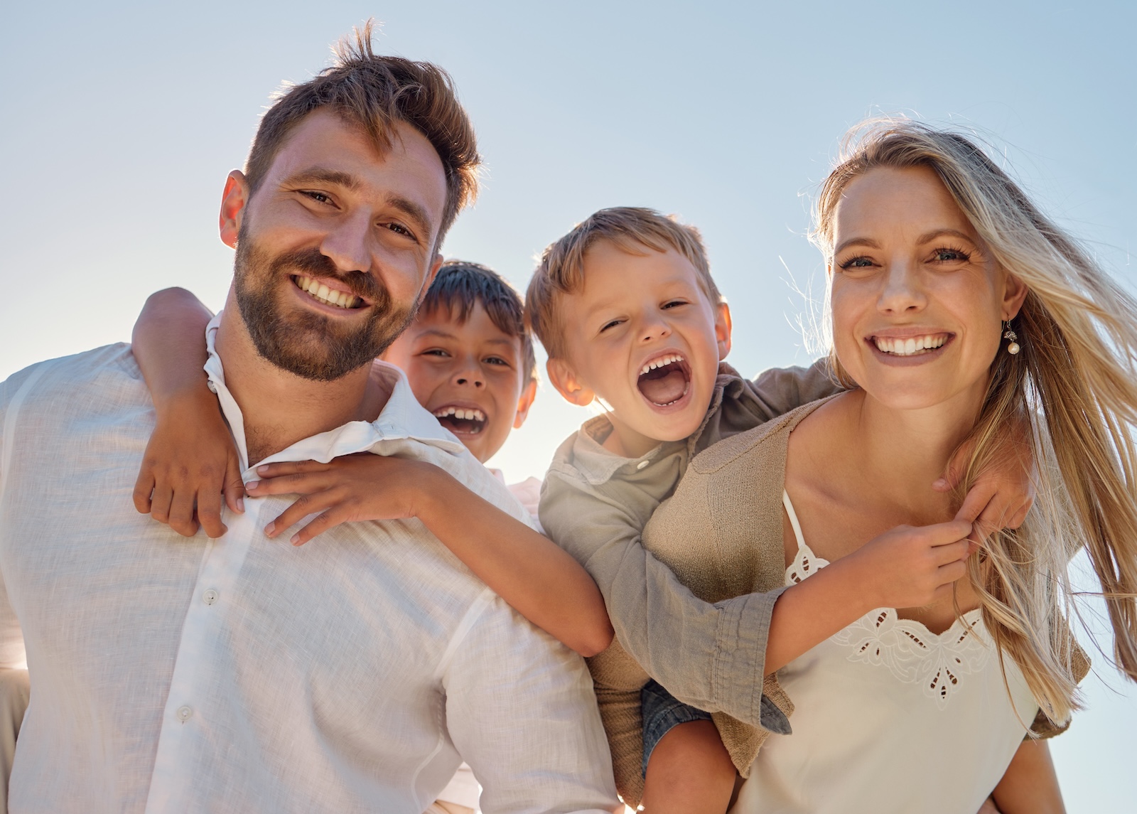 Caucasian parents with two little boys at the beach on a summer day.