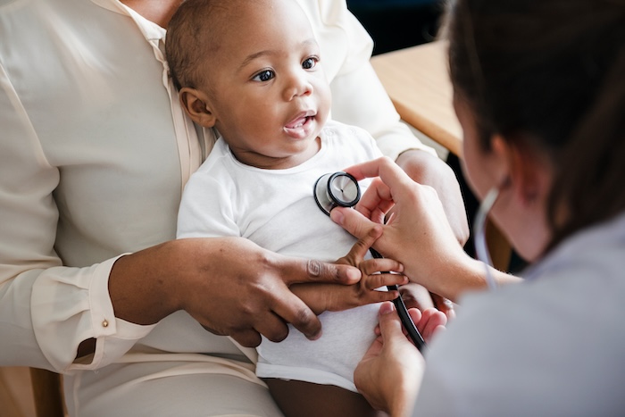 Black baby with mom at a pediatrics appointment.