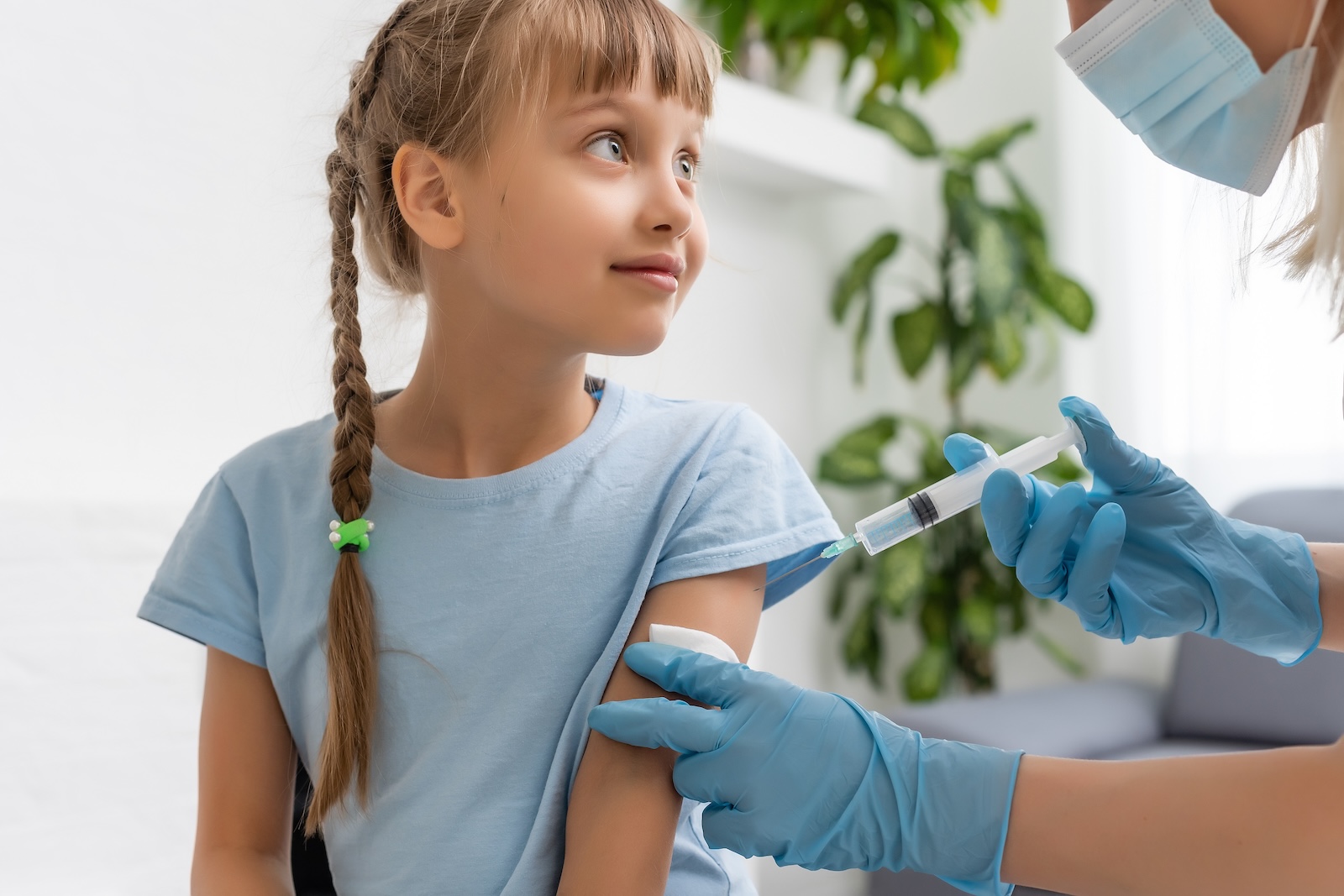 Young caucasian girl receiving a vaccination at a flu clinic.